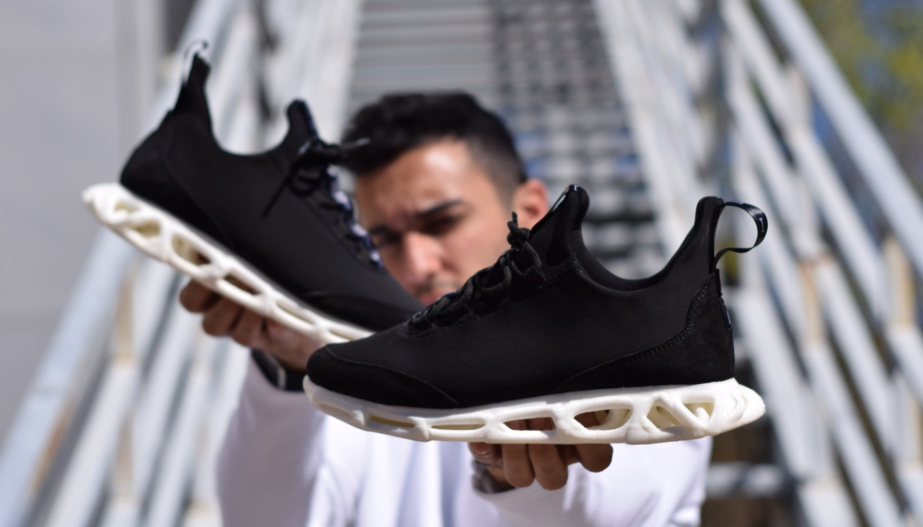 Kike Millan sosteniendo unas zapatillas Fick con suela impresa en 3D